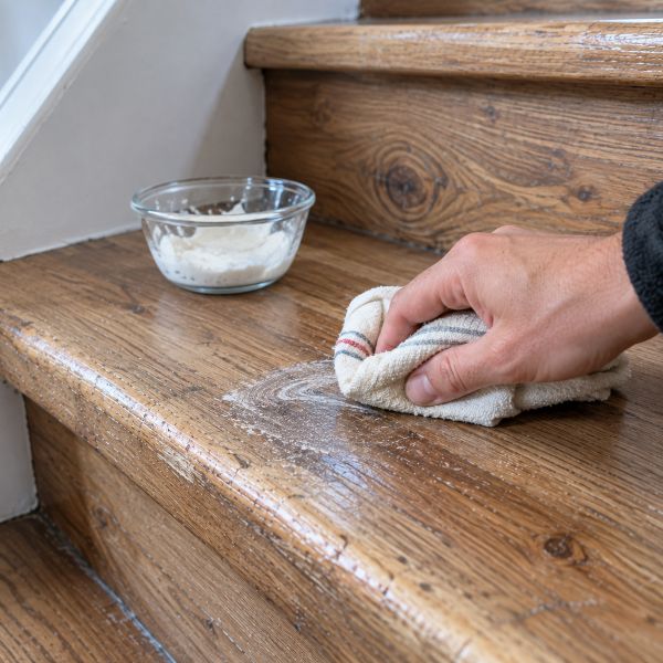 Nettoyage d'une marche en bois avec une pâte de bicarbonate de soude